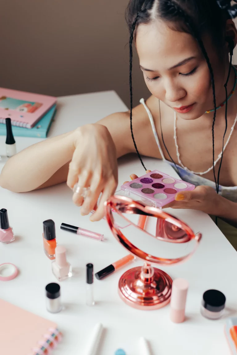 Dziewczyna podczas tworzenia makijażu karnawałowego z użyciem technik poznanych na kursie wizażu