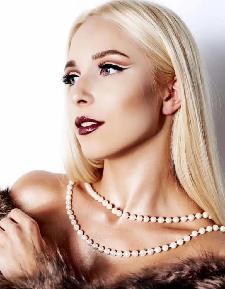 Elegancki makijaż sylwestrowy z mocnym rozświetleniem skóry, wyrazistymi ustami i klasycznym lookiem podkreślającym rysy twarzy.