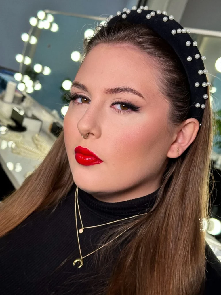 Makijaż sylwestrowy z czerwonymi ustami, gładką cerą i subtelnie podkreślonymi oczami
