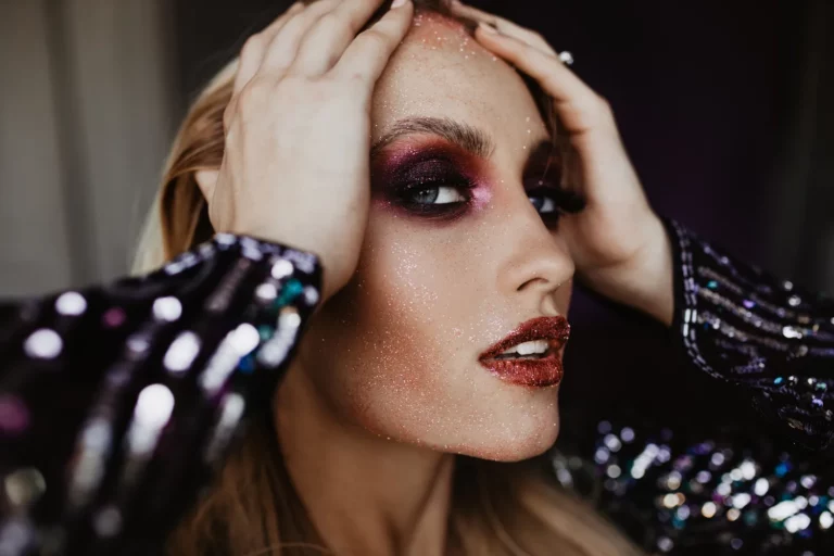 Młoda piekna kobieta, która ma zrobiony na twarzy sylwestrony makijaż typu bold eyes.