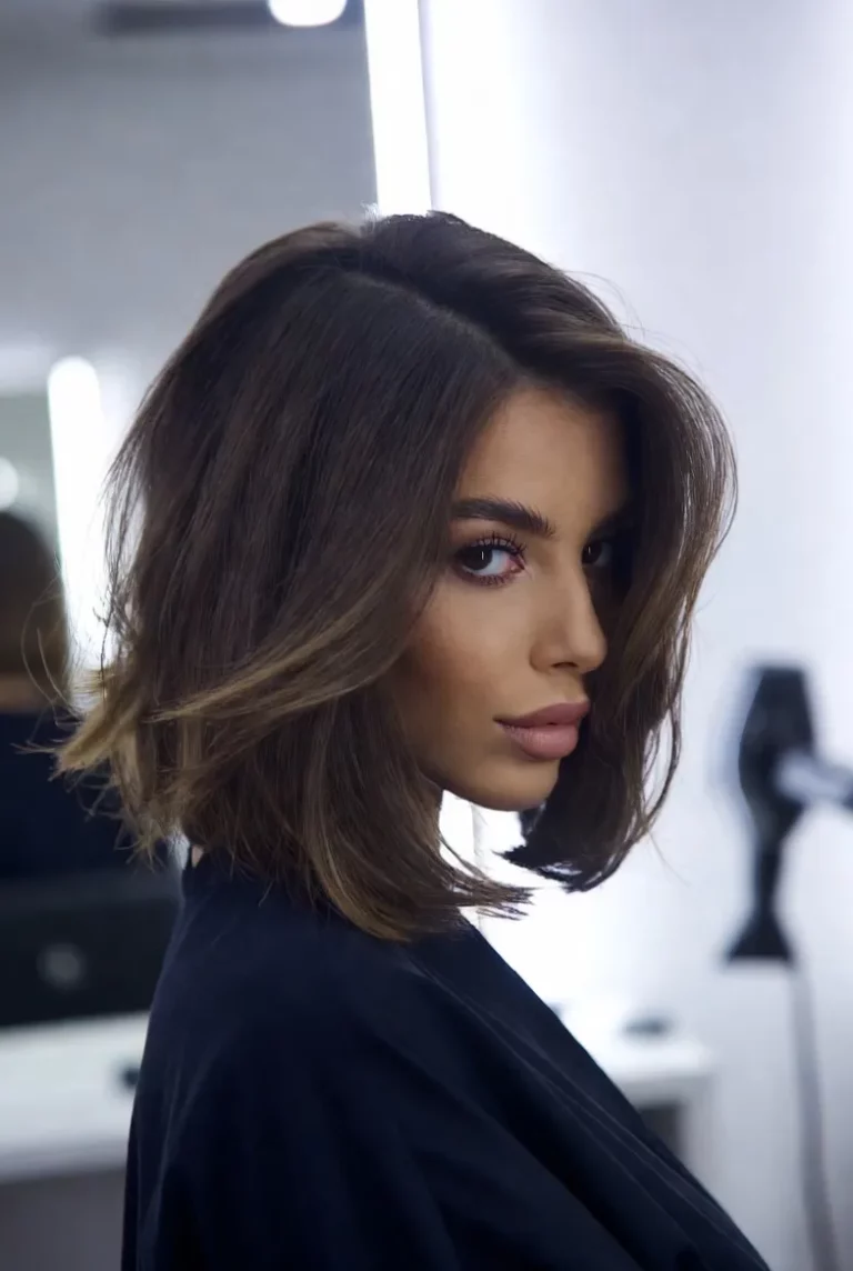 Kobieta z elegancką fryzurą feathered bob w salonie fryzjerskim, przykład stylizacji uczonej w szkoła fryzjerska Warszawa oraz na kurs fryzjerski Warszawa